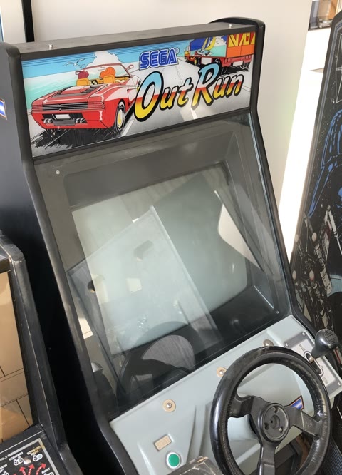 Alex's Sega OutRun mini upright arcade cabinet, with the marquee of the red Ferrari and a lorry on a coastal road, a steering wheel and the two-position Low/High gearstick